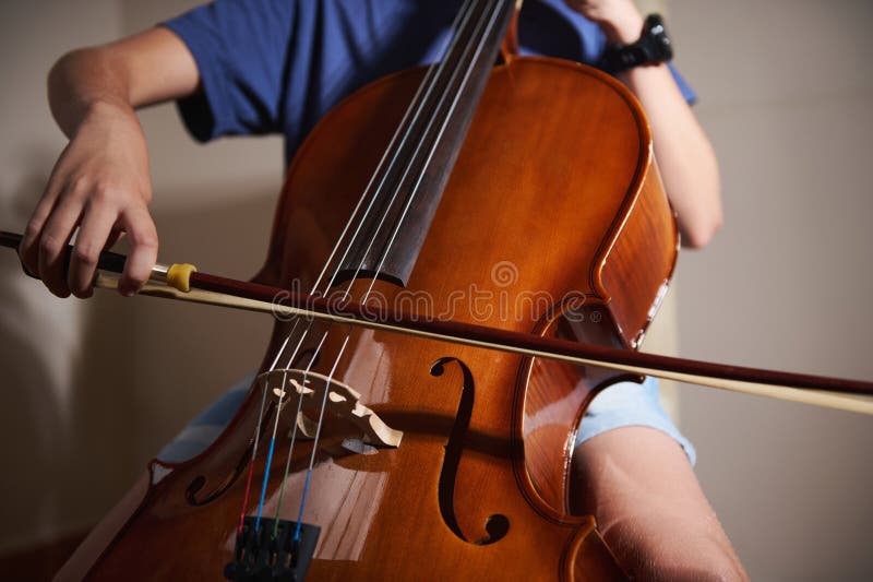 Close-Up of a Person Playing the Cello with Precision and Focus in a Music Studio royalty free stock photos