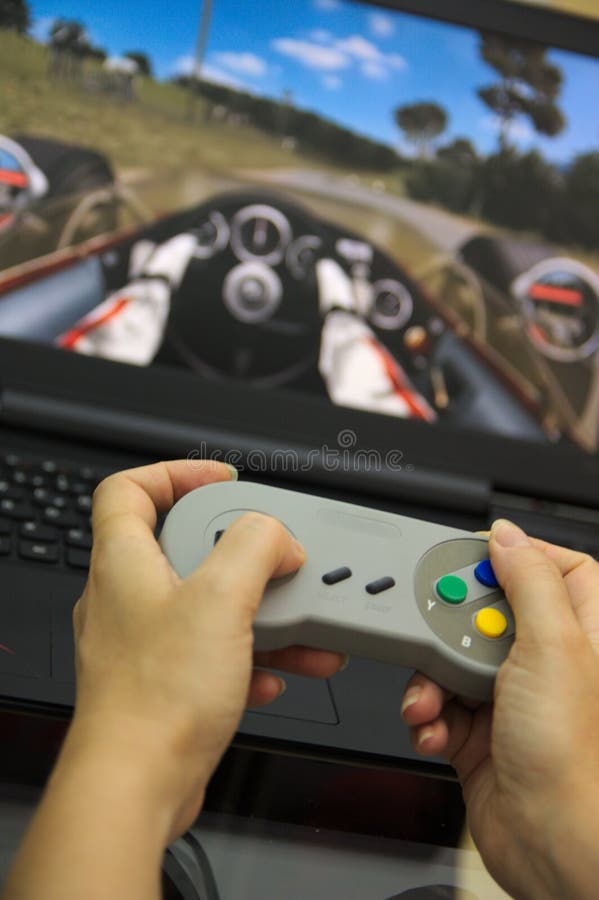 Someone playing with a gamepad on the computer stock images