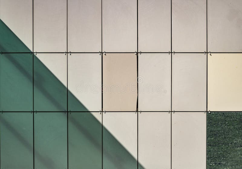 Close-up photo of building facade tiles. Abstract green and yellow background image on the subject of modern architecture, industry or technology