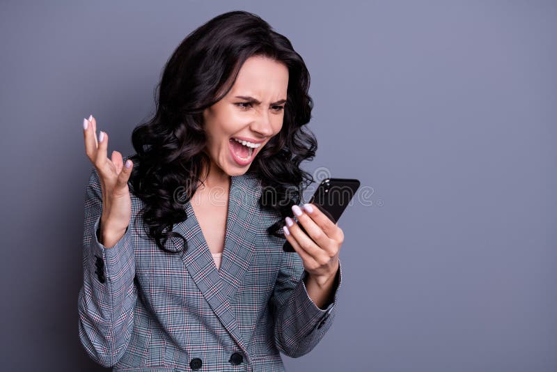 Close up photo of crazy curly, haired executive holding device using loud-speaker yelling scolding wearing jacket blazer isolated over gray background. Close up photo of crazy curly, haired executive holding device using loud-speaker yelling scolding wearing jacket blazer isolated over gray background