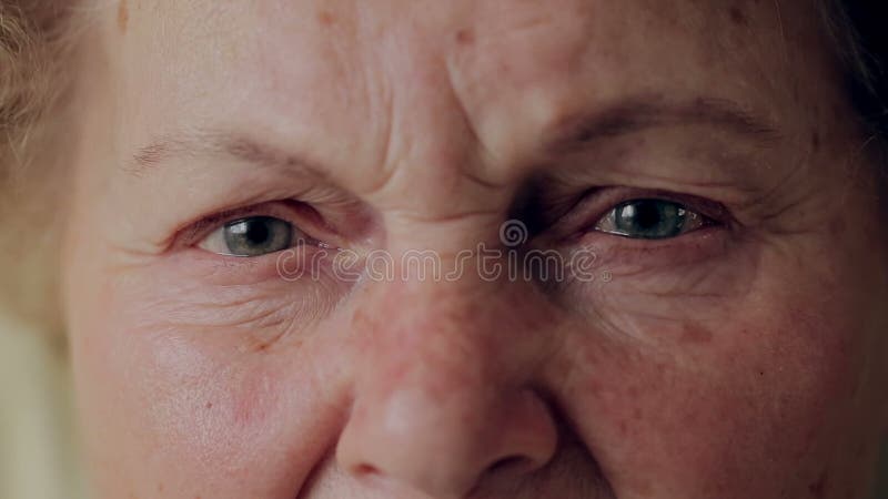 Close up photo of elderly woman eye. Senior portrait, happy old woman with eyeglasses smiling and looking at camera