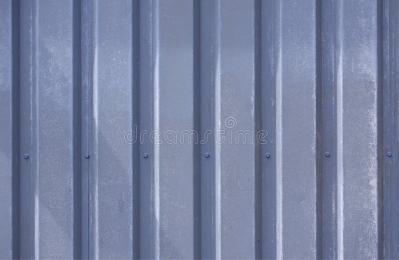 Close up photo of a facade from an industrial building with graphic stripes of minimalistic vertical blue weathered metal profiles royalty free stock photo