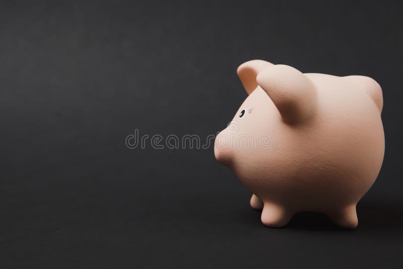 Close up photo, side view of pink piggy money bank on black wall background. Money accumulation, investment royalty free stock photography