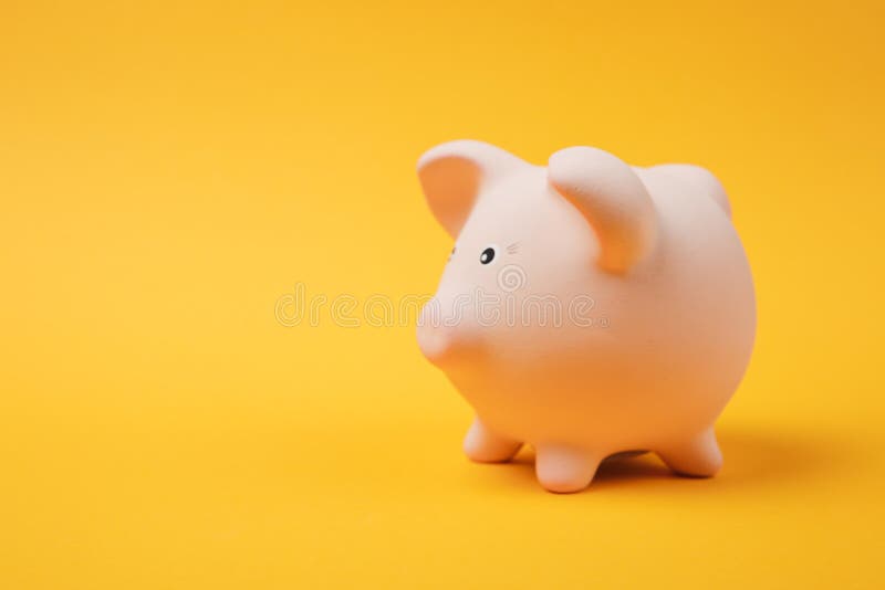 Close up photo, side view of pink piggy money bank on bright yellow wall background. Money accumulation stock images