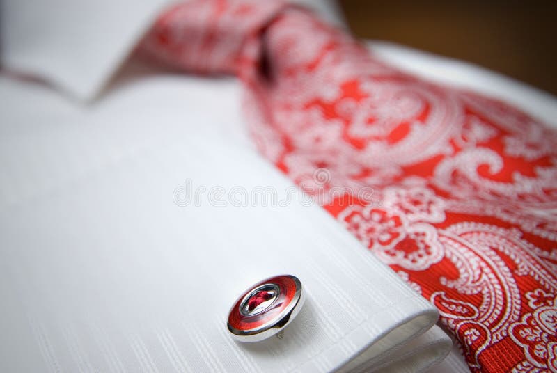 Close-up photo of stud on white shirt with red tie