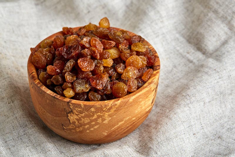 Wooden Bowl with Golden Raisins on Light Tablecloth, Close-up ...