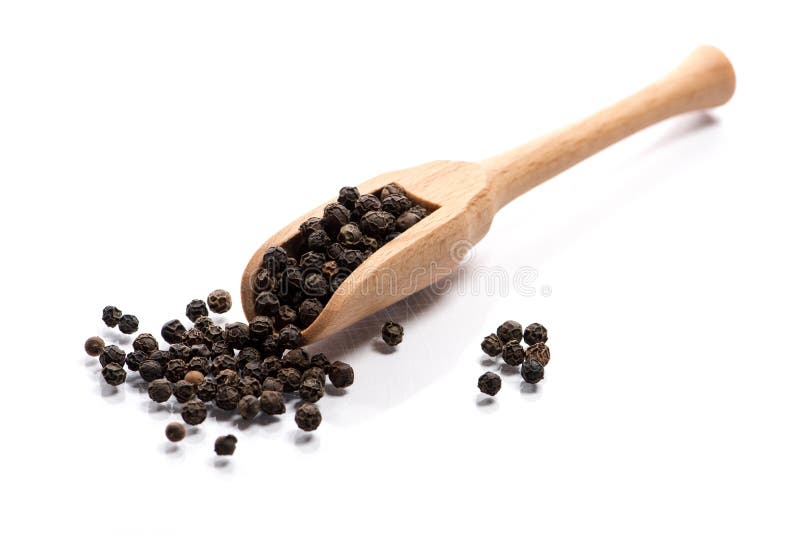 Close-up of pile of Black pepper seeds spice in a wooden spoon o