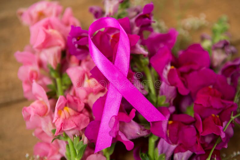 Close Up Of Pink Breast Cancer Awareness Ribbon On Flowers Stock Photo