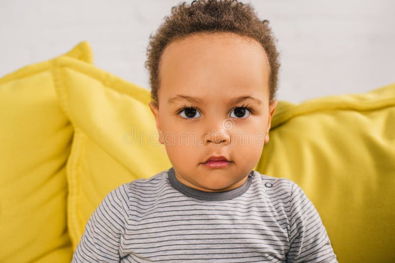 close-up portrait of adorable african american toddler looking at camera while sitting