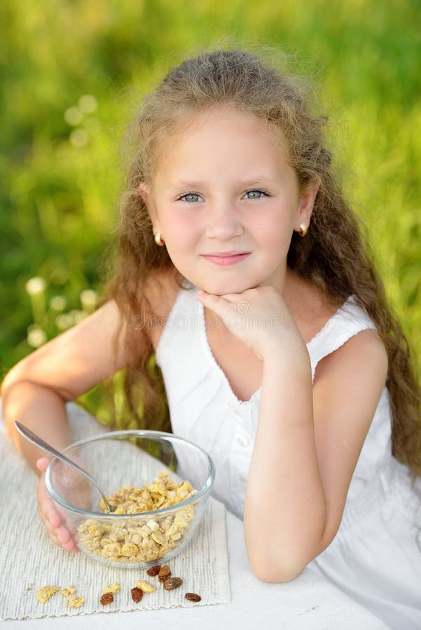 Close up portrait of adorable girl having breakfast and drinking milk outdoor. Cereal, healthy lifestyle stock images Close up portrait of adorable girl having breakfast and drinking milk outdoor. Cereal, healthy lifestyle stock images