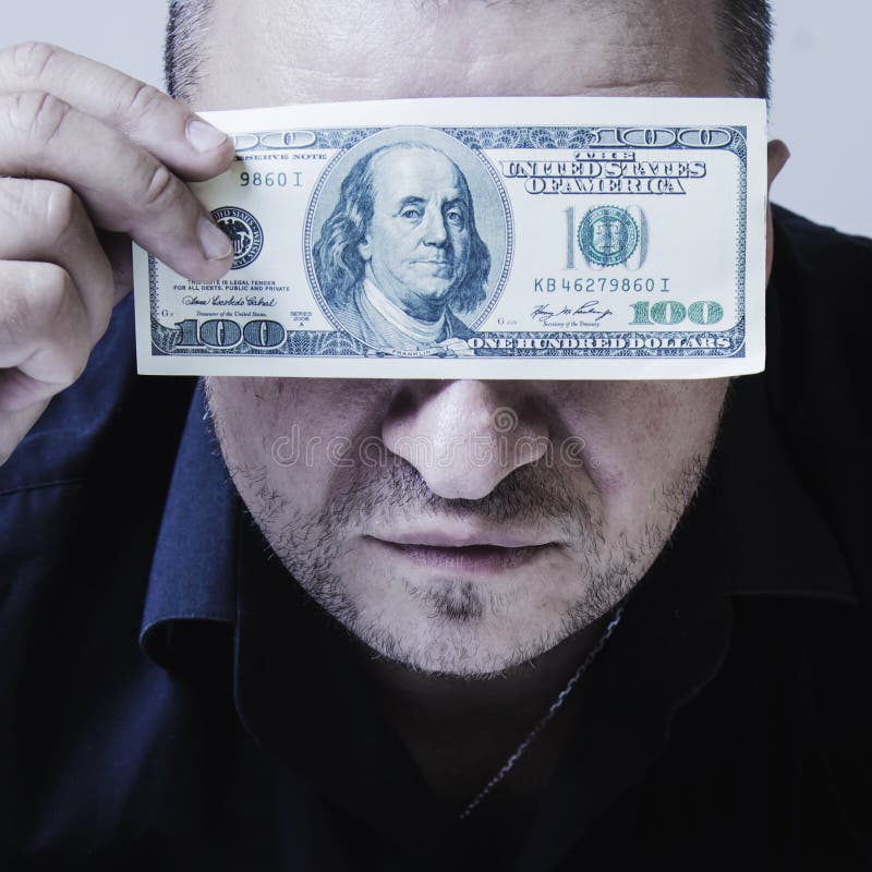 Close up portrait of adult brutal businessman holds US Dollar bills in front of eyes as if he wants to say: I see nothing but stock photos Close up portrait of adult brutal businessman holds US Dollar bills in front of eyes as if he wants to say: I see nothing but stock photos