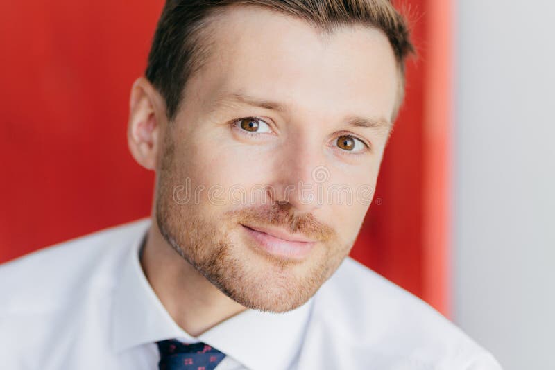 Close up portrait of attractive unshaven male looks at camera, involved in business affairs, being confident in his strength, pose stock images Close up portrait of attractive unshaven male looks at camera, involved in business affairs, being confident in his strength, pose stock images