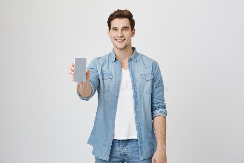 Close up portrait of attractive young model with trendy hairstyle and outfit, presenting new smartphone for advertising royalty free stock images Close up portrait of attractive young model with trendy hairstyle and outfit, presenting new smartphone for advertising royalty free stock images