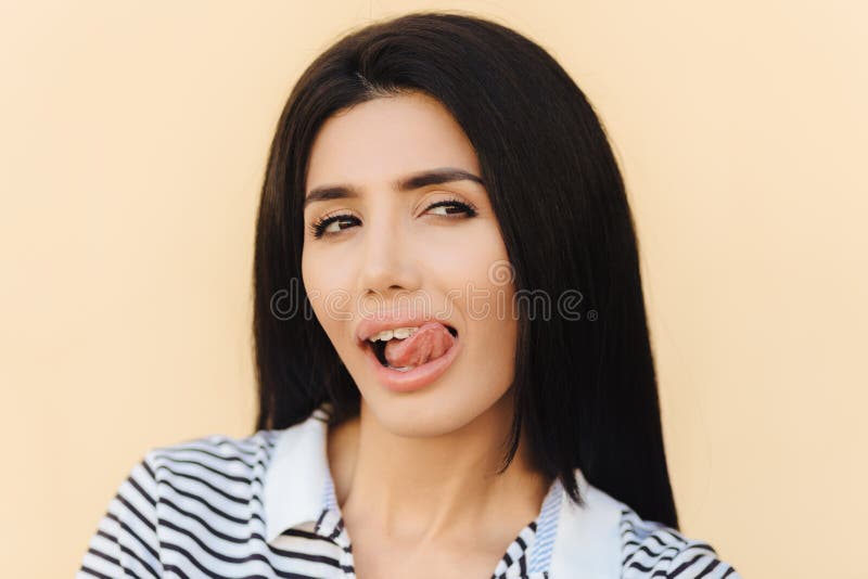 Close Up Portrait Of Beautiful Brunette Female Licks Lips With Tongue Looks Mysteriously Aside