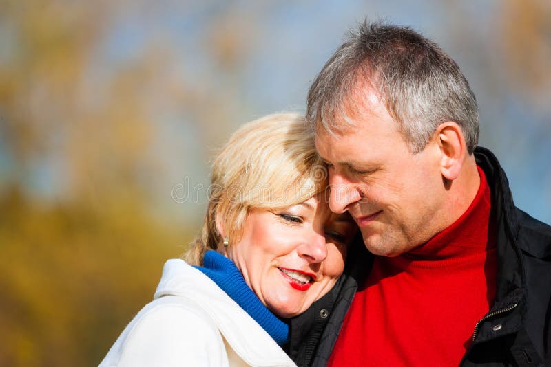 Retired senior couple embracing in park stock images Retired senior couple embracing in park stock images