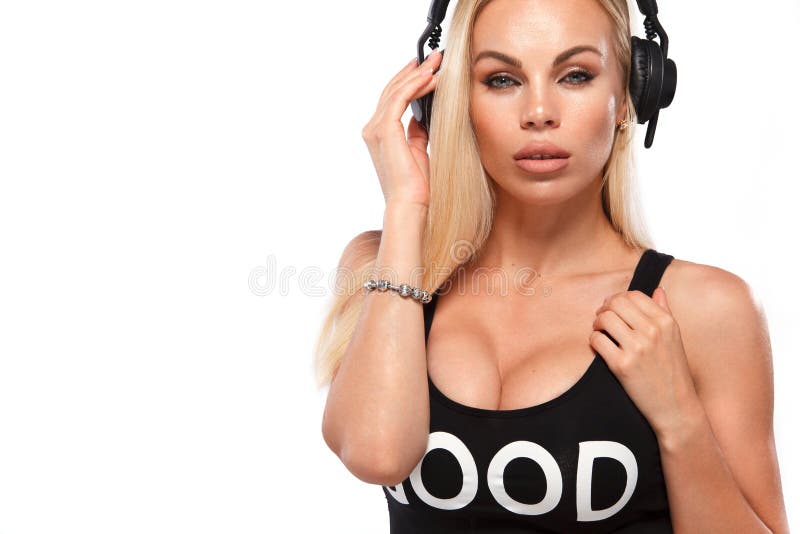 Close-up portrait of beautiful blonde DJ woman on white background in studio wearing headphones.