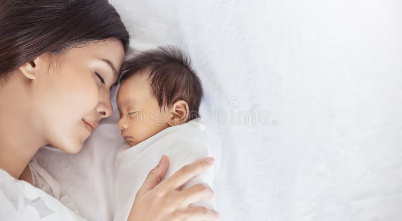 Close up portrait of beautiful young asian or caucasian mother with her healthy newborn baby.