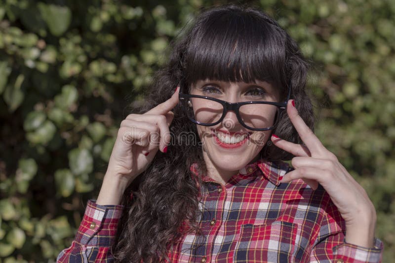 close up portrait of a beautiful young woman adjusting glasses and looking at the camera smiling. Fun and lifestyle royalty free stock image close up portrait of a beautiful young woman adjusting glasses and looking at the camera smiling. Fun and lifestyle royalty free stock image