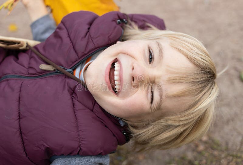 close-up portrait of a cute boy 6-7 years old walking in the park in autumn or spring