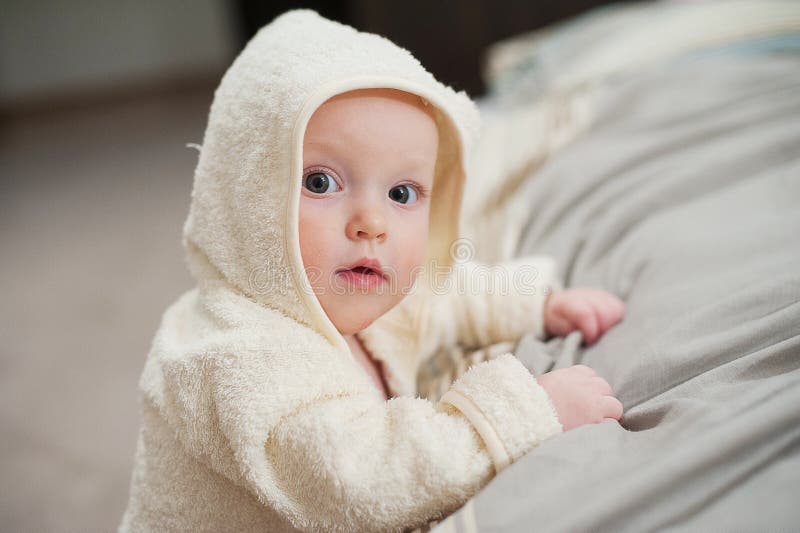 Close up portrait of cute funny baby in bathrobe. royalty free stock photography