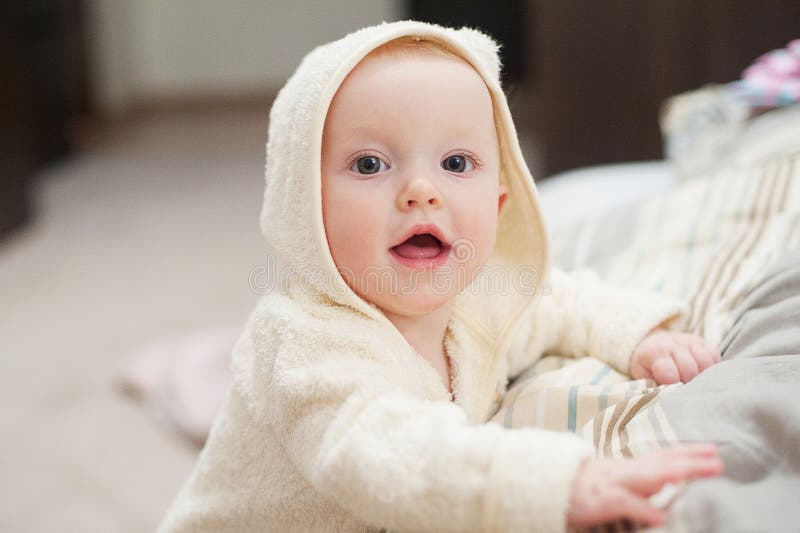Close up portrait of cute funny baby in bathrobe. royalty free stock photo