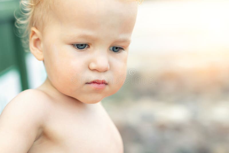 Close-up portrait of cute pensive upset caucasian 2 year old toddler boy portrait standing alone at beach summer day and stock images Close-up portrait of cute pensive upset caucasian 2 year old toddler boy portrait standing alone at beach summer day and stock images