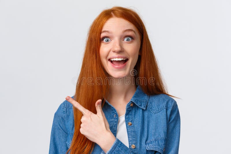 Close-up portrait excited happy ginger girl, foxy hair and blue eyes, smiling upbeat with amazement and joy, pointing royalty free stock image Close-up portrait excited happy ginger girl, foxy hair and blue eyes, smiling upbeat with amazement and joy, pointing royalty free stock image