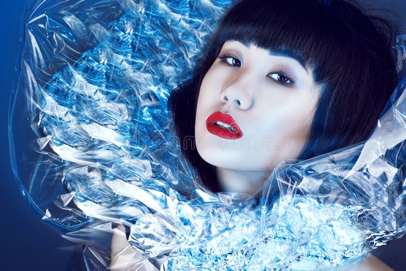 Gorgeous Asian model with beautiful make up and trendy haircut with fringe wearing fancy shining stand-up collar. royalty free stock image Gorgeous Asian model with beautiful make up and trendy haircut with fringe wearing fancy shining stand-up collar. royalty free stock image