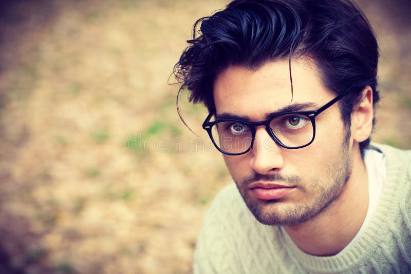 Close-up portrait of a handsome young man with glasses.