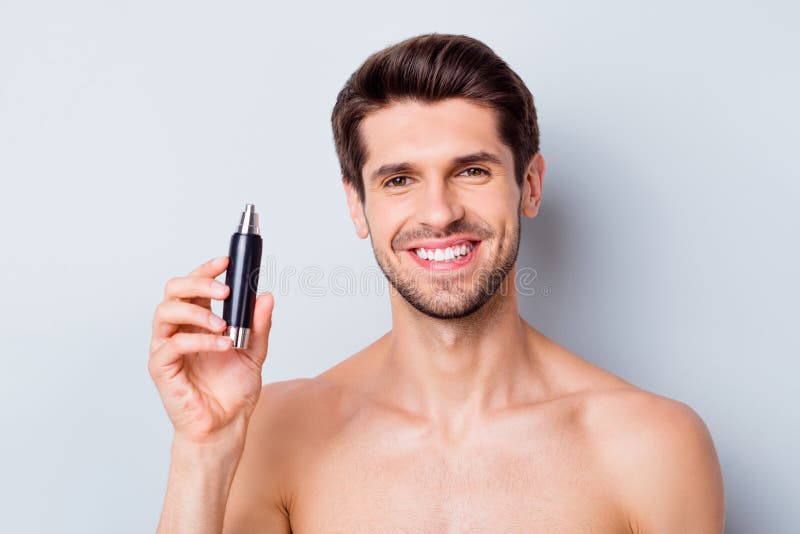 Close-up portrait of his he nice attractive bearded groomed cheerful cheery glad brown-haired guy holding in hand