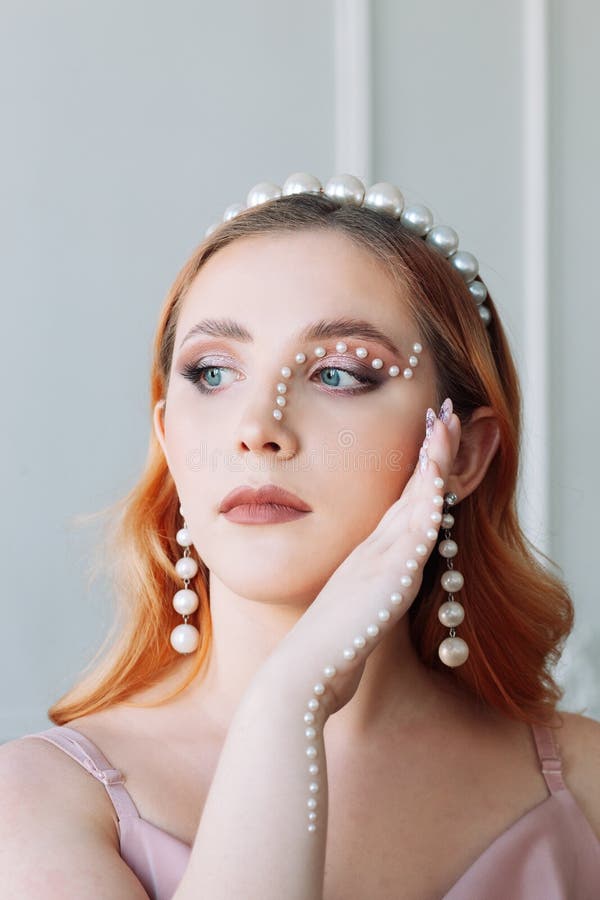 Close-up portrait of a pale-skinned Caucasian woman with pearl makeup in the form of a curved line on her face and hands stock images Close-up portrait of a pale-skinned Caucasian woman with pearl makeup in the form of a curved line on her face and hands stock images