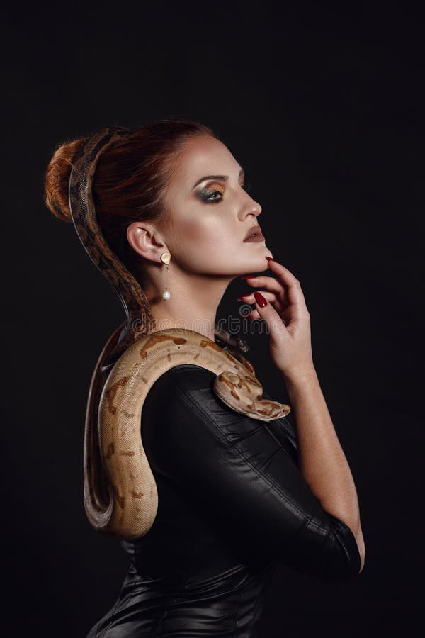 Close up portrait of sexy woman with snake in latex outfit