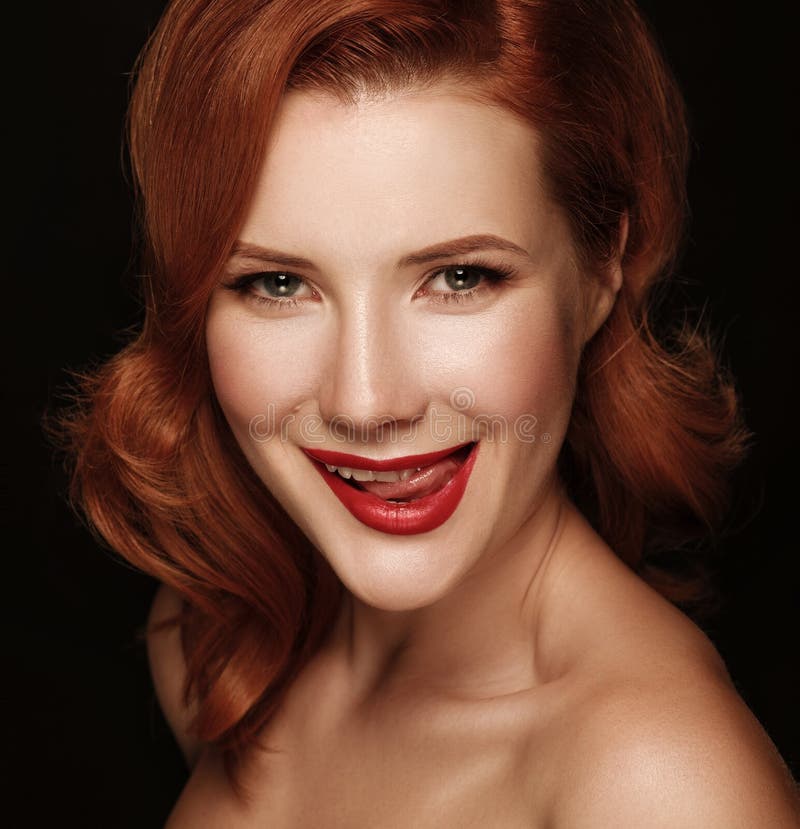 Close-up portrait of a smiling beautiful red-haired girl.