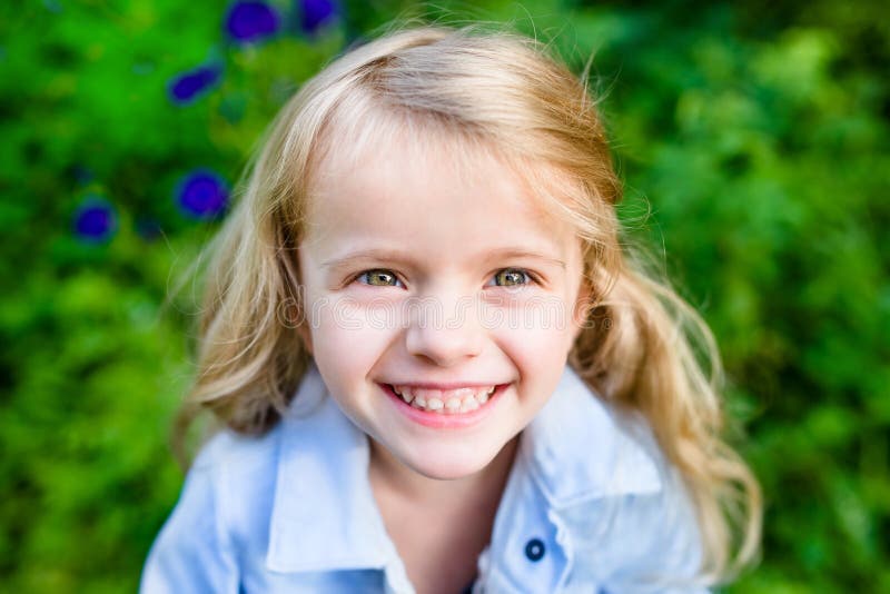 Close-up portrait of a smiling blond little girl