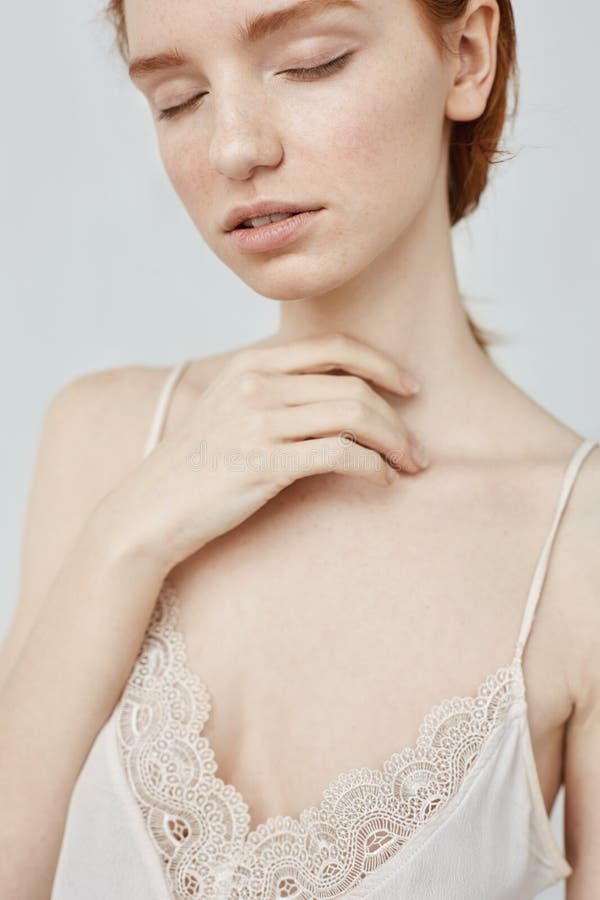 Close up portrait of tender redhead girl posing with closed eyes.