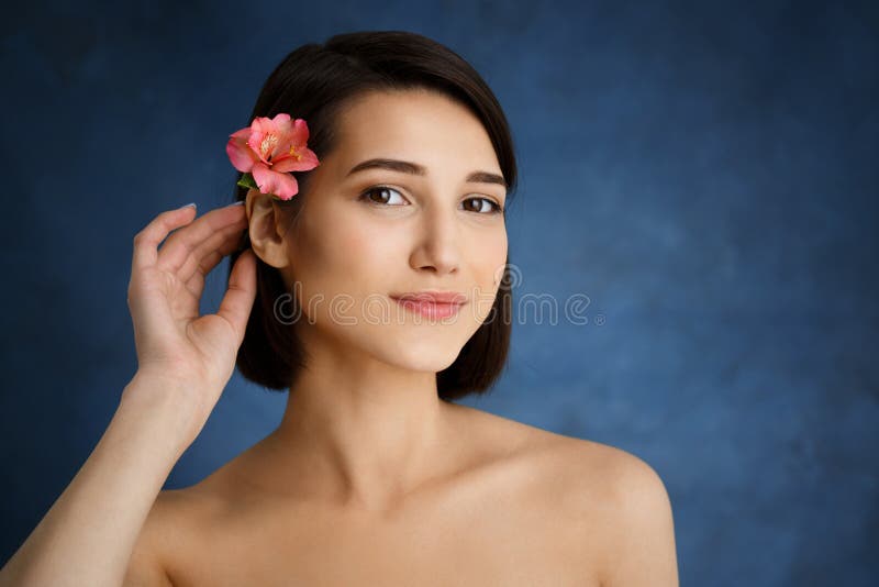 Close Up Portrait of Tender Young Girl with Pink Flower in Ha picture