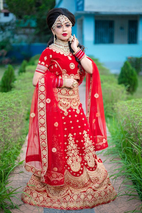 Close up Portrait of very beautiful sexy indian bride in red lehenga showing navel. Non Bengali bridal portrait