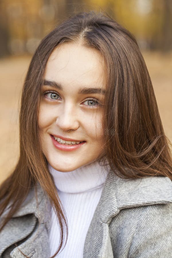 Close up portrait of a young beautiful woman in autumn park