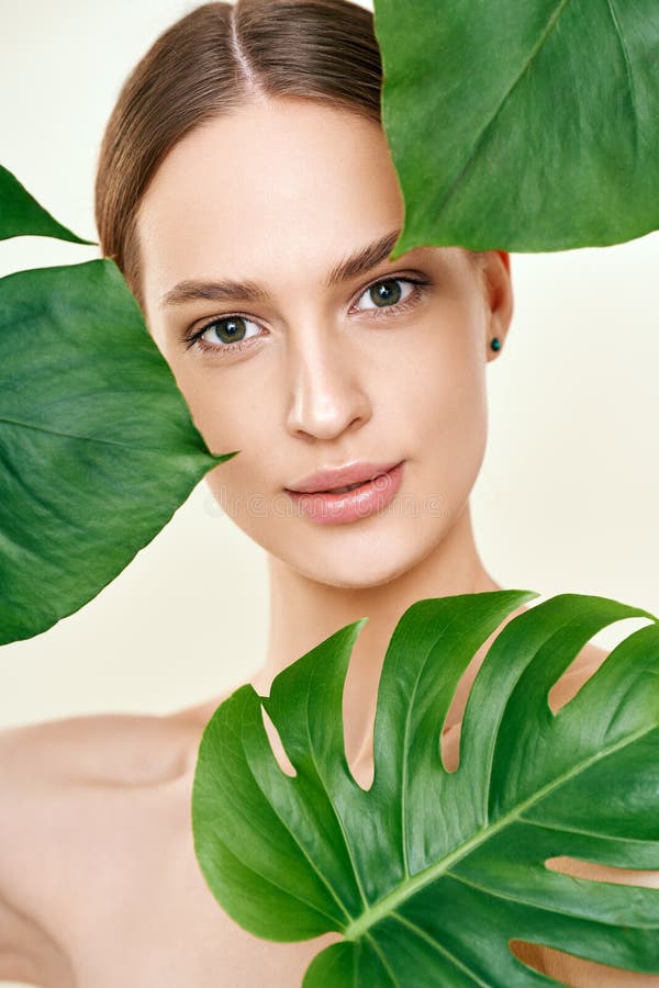 Close Up Portrait Of Young Beautiful Woman With Perfect Smooth Skin In Tropical Leave Stock 