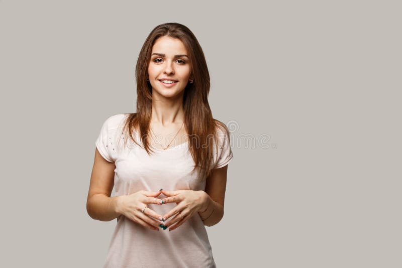 Close up portrait of young cheerful beautiful girl with dark hair in casual shirt smiling and looking in camera.