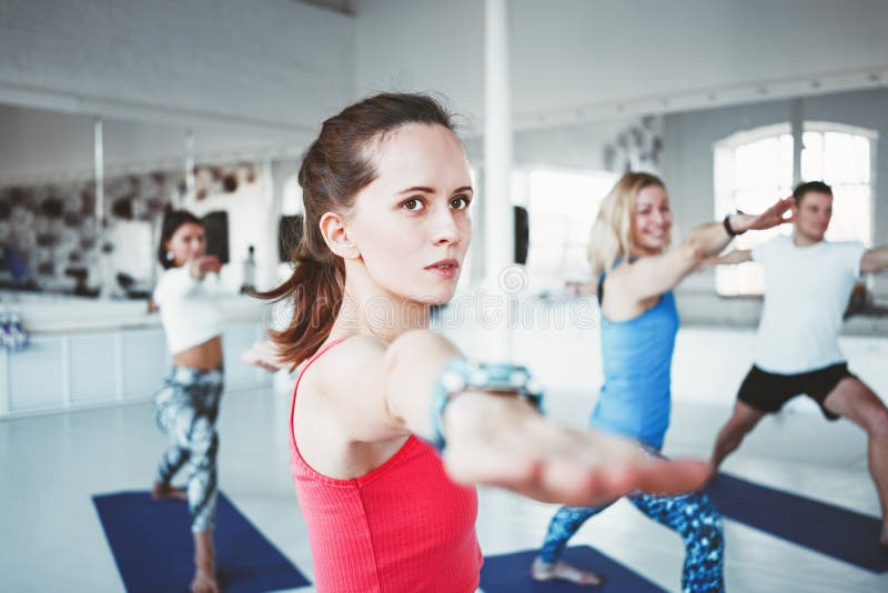Close up portrait of young healthy woman doing yoga exercise indoor class together with group. Blurred background royalty free stock photos Close up portrait of young healthy woman doing yoga exercise indoor class together with group. Blurred background royalty free stock photos