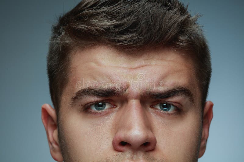 Close-up portrait of young man  on grey studio background