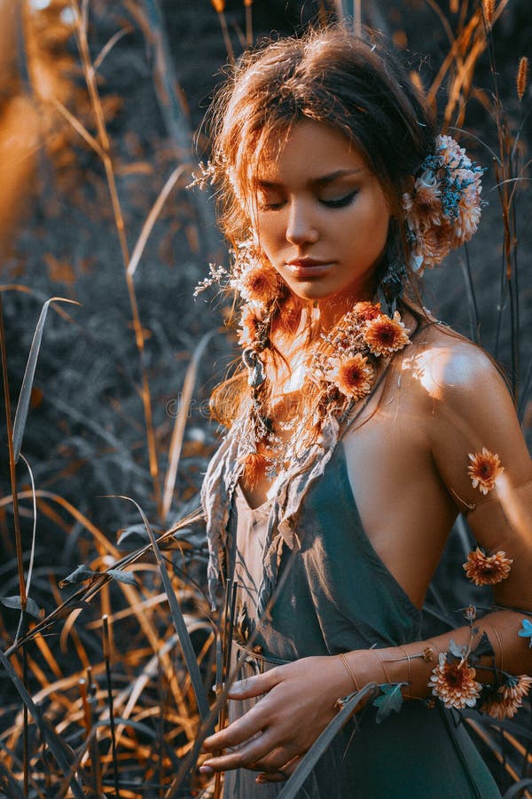 Close up portrait of young and tender woman on a feild at sunset