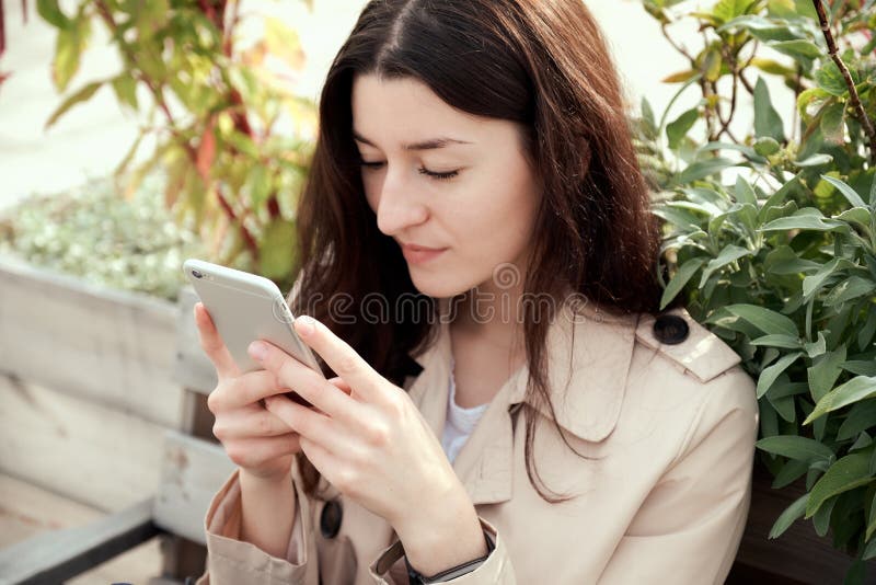 Close up portrait of young woman holding smartphone in her hands stock photography Close up portrait of young woman holding smartphone in her hands stock photography