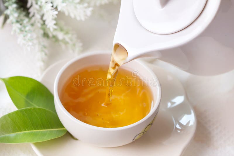 Close up pouring hot black tea in a white tea cup , Tea ceremon