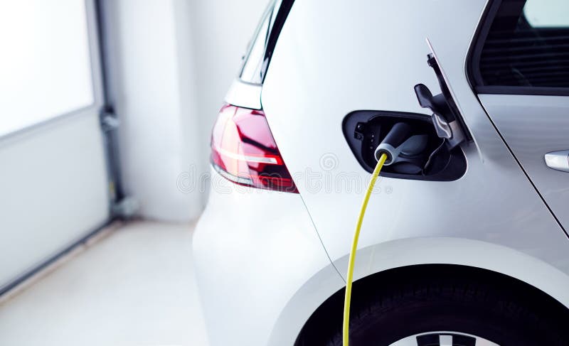 Close Up Of Power Cable Charging Environmentally Friendly Zero Emission Electric Car In Garage stock photography