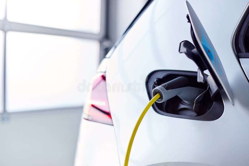 Close Up Of Power Cable Charging Environmentally Friendly Zero Emission Electric Car In Garage stock photos