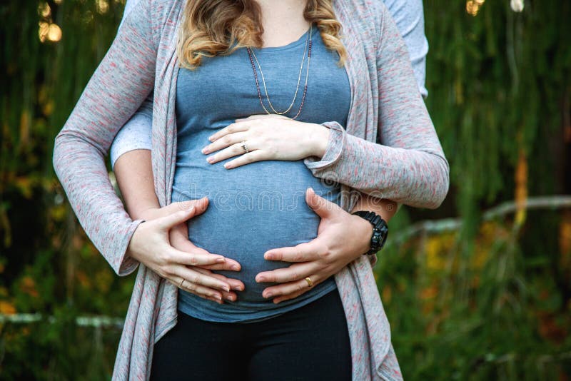 Close up of pregnant couple with hands on belly royalty free stock photos