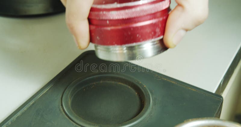 Close-up of the process of making ground coffee. Professional barista tamping ground coffee stock footage
