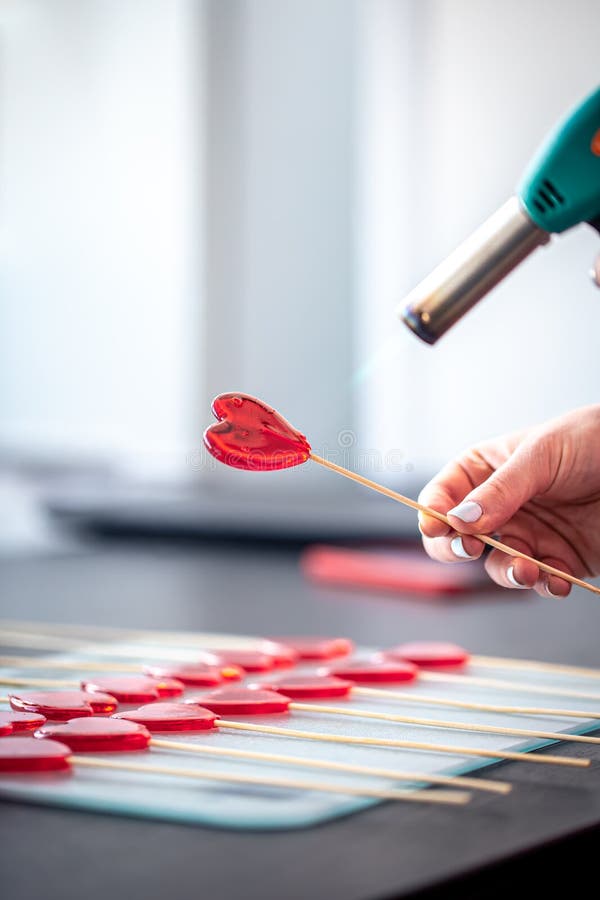 Close-up, the process of making heart-shaped lollipops.